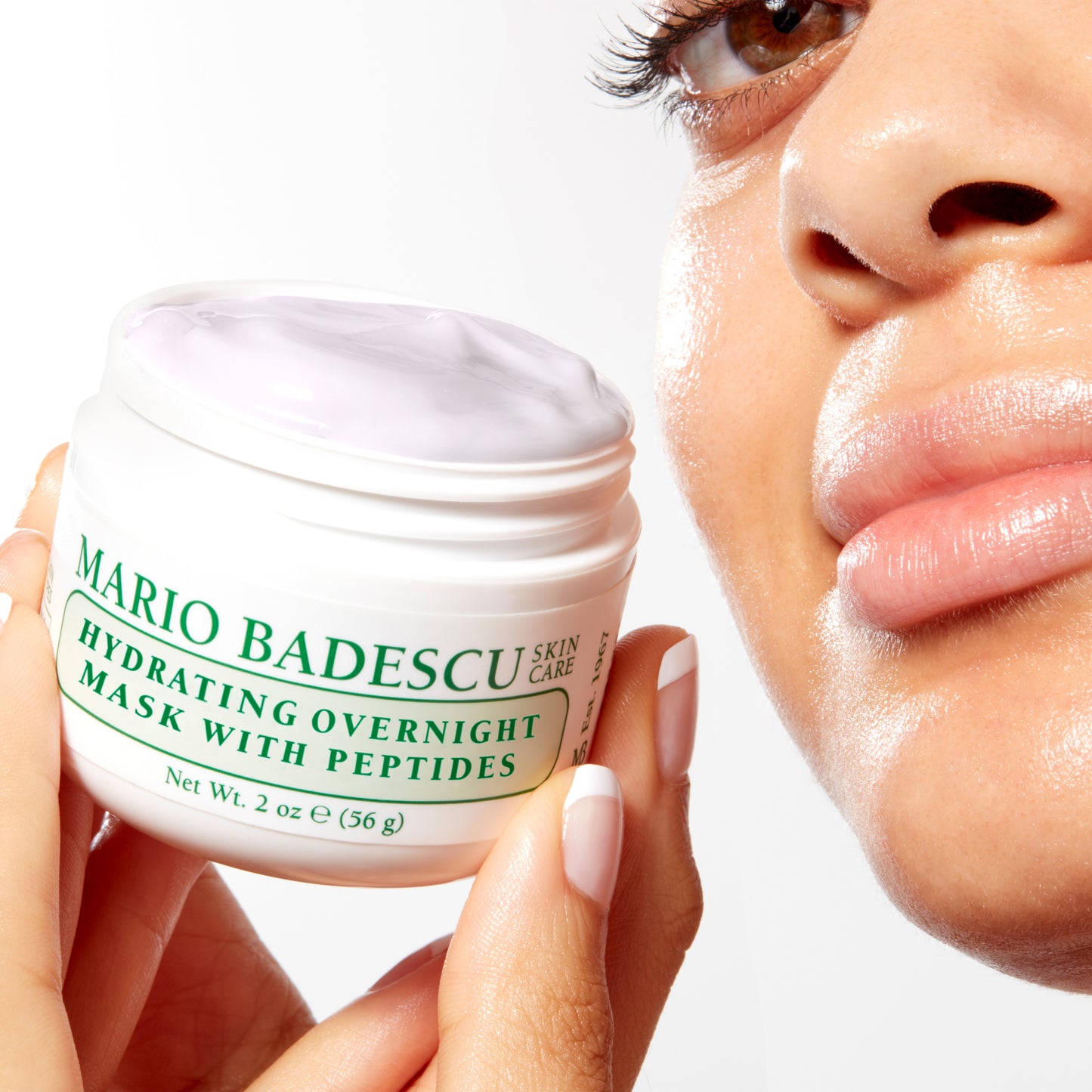 Woman with glowing skin holding Hydrating Overnight Face Mask with Peptides