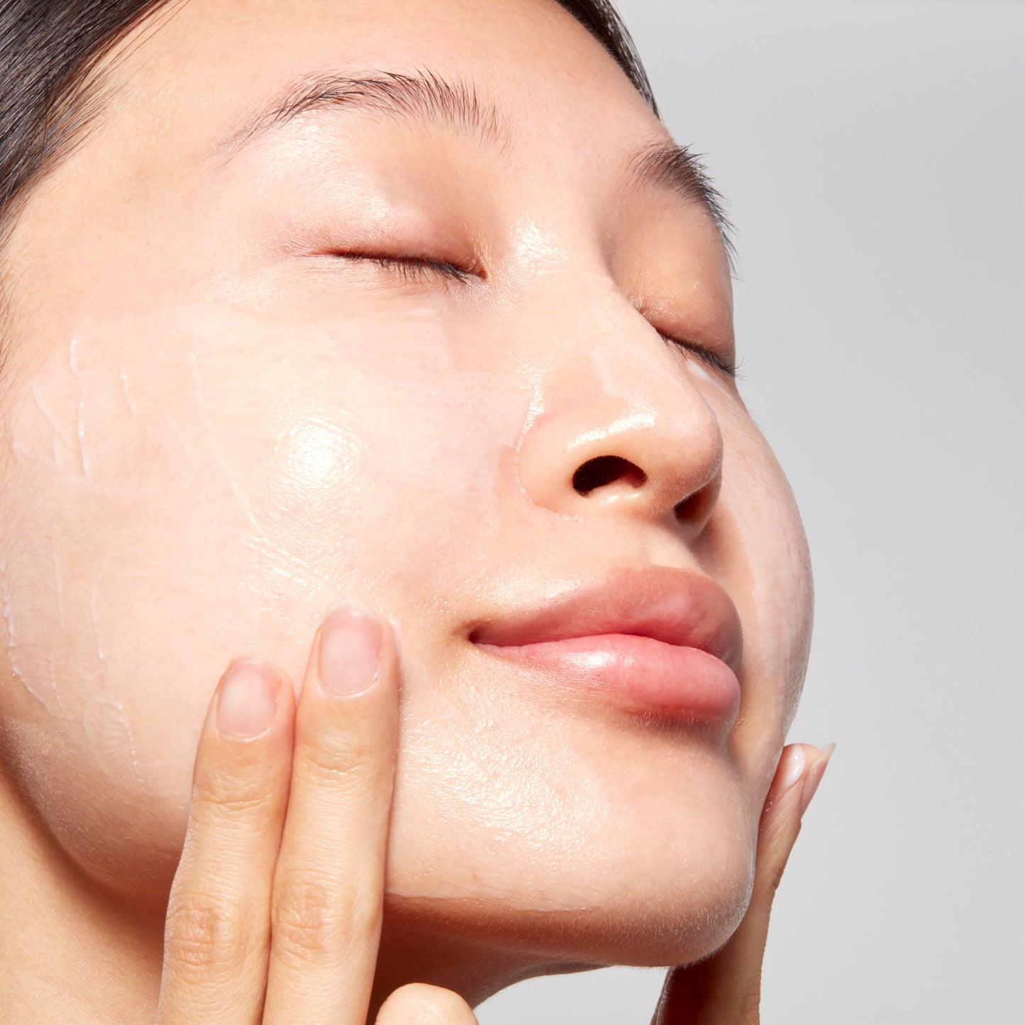Woman demonstrating how to apply Hydrating Overnight Face Mask with Peptides