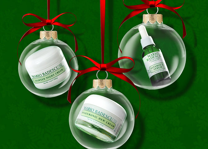 Mario Badescu skincare products in Christmas ornament packaging on a green background