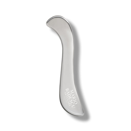 Silver body massager with Mario Badescu logo on a white background