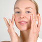 Woman showing application of Botanical Exfoliating Scrub