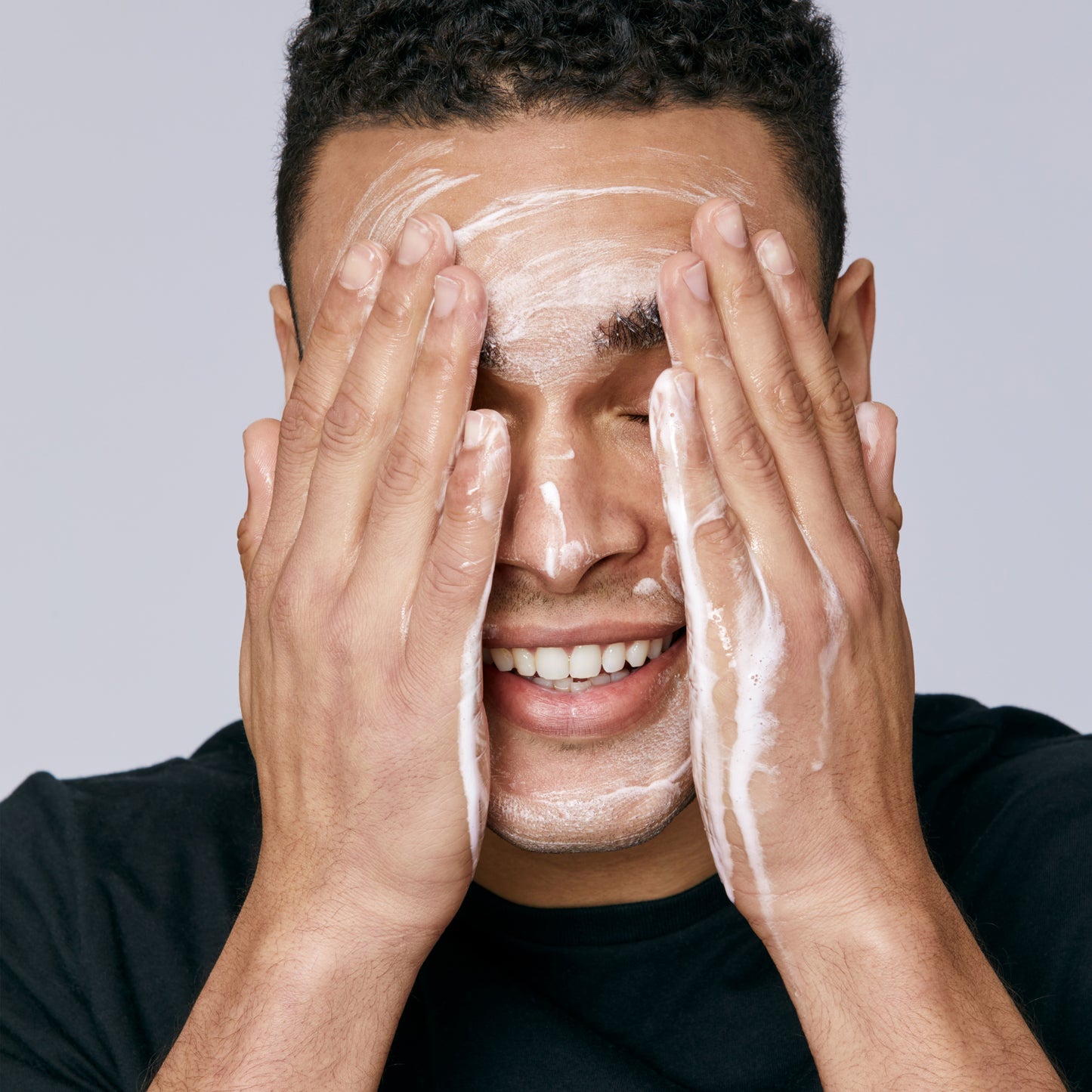 Demonstration showing a man using Acne Facial Cleanser on his face 