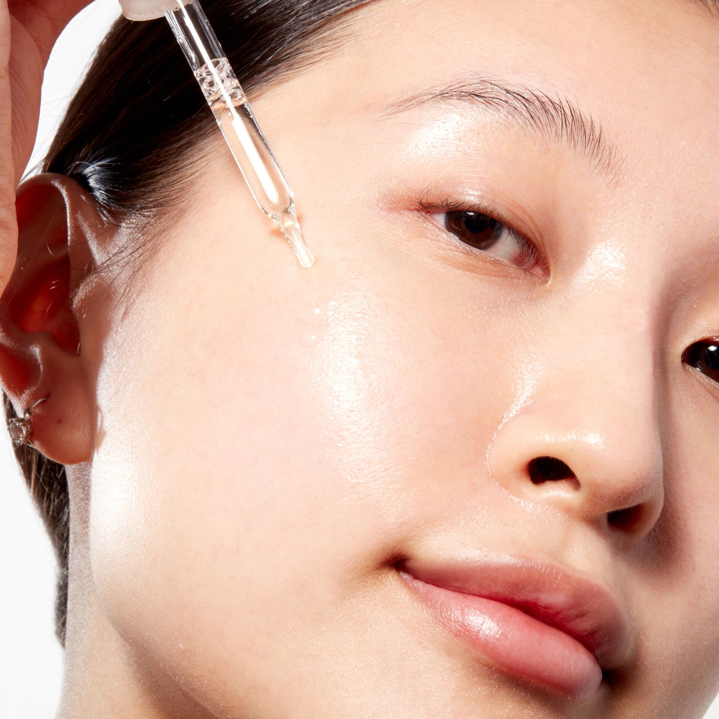 Woman demonstrating how to apply Vitamin C Serum